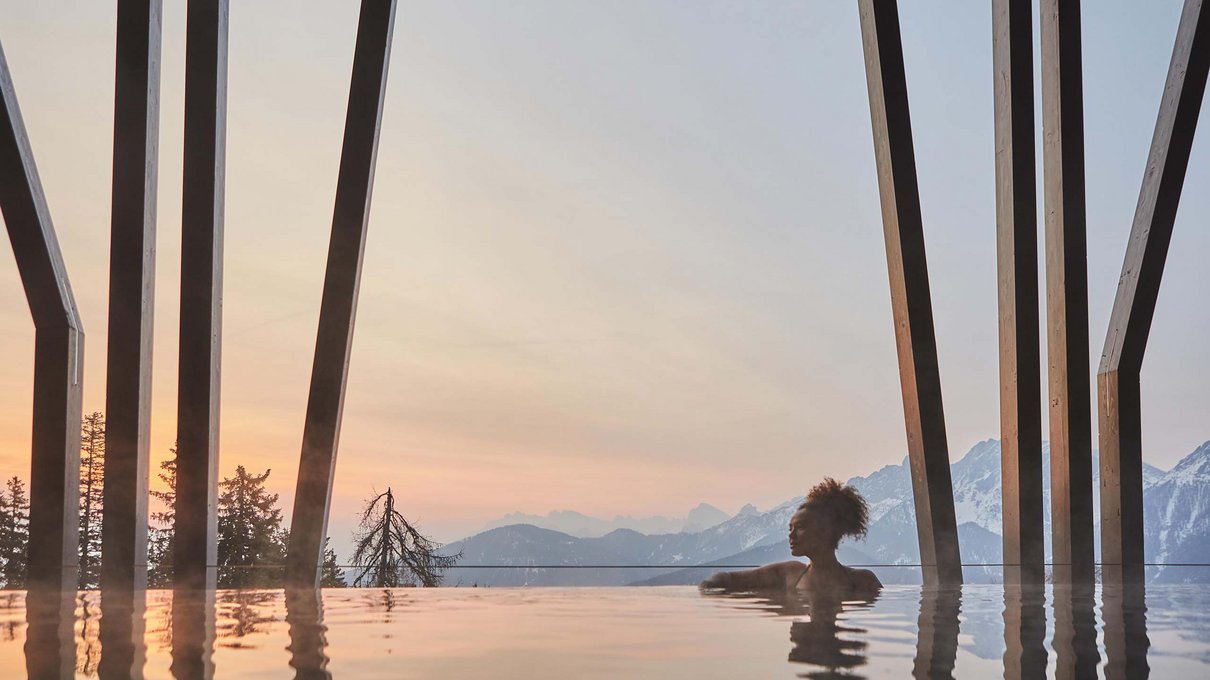 Deine Unterkunft im Pustertal: oh, wow! Frau im beheizten Pool mit Bergblick bei Sonnenuntergang