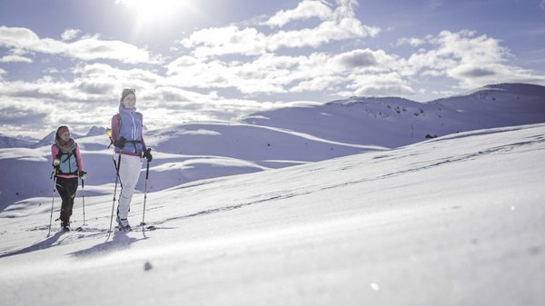 Kronplatz + Hotel an der Piste = Olangerhof Zwei Frauen beim Skitourengehen auf einem schneebedeckten Berg