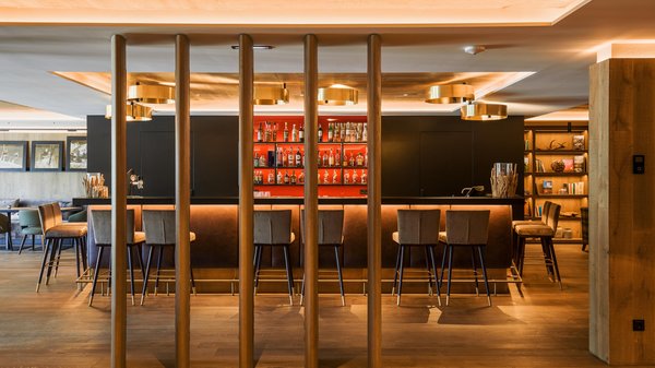 A Valdaora: l’hotel da “oh” Bar moderno con sedie alte e scaffali di bottiglie illuminate da luci calde