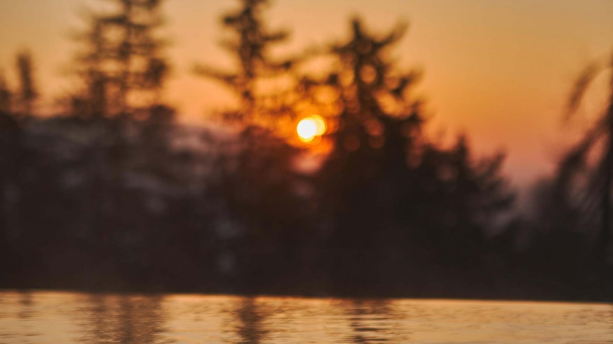 Deine Unterkunft im Pustertal: oh, wow! Sonnenuntergang mit Bäumen und Spiegelung auf ruhigem Wasser