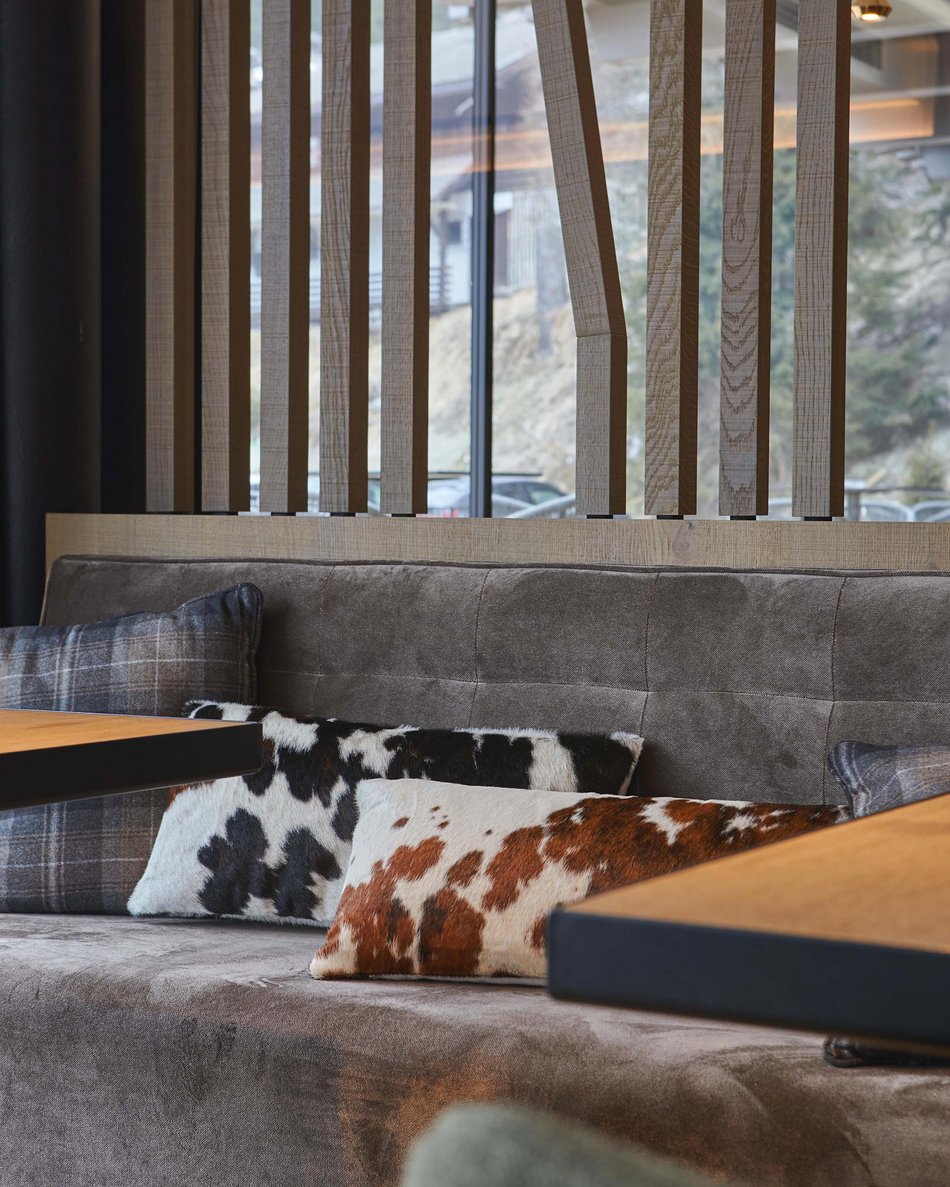 A Valdaora: l’hotel da “oh” Divano grigio con cuscini a fantasia animale in un interno moderno