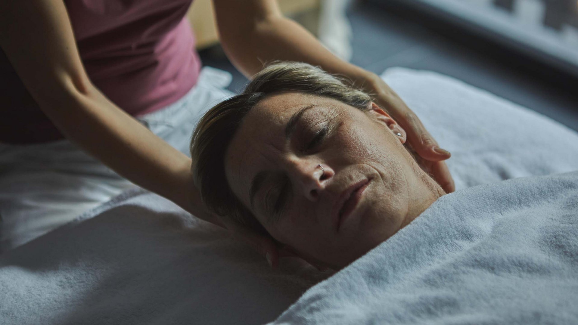 Dein Wellnesshotel am Kronplatz: Olangerhof Frau erhält eine entspannende Kopf- und Nackenmassage