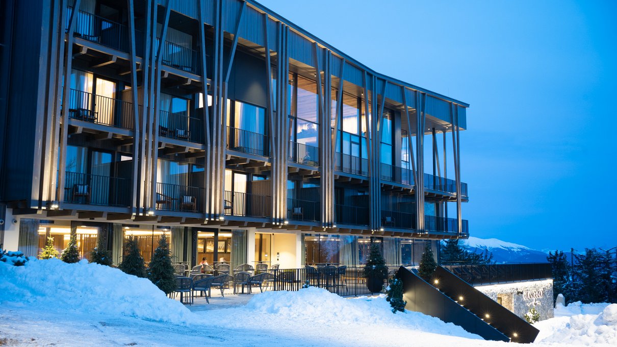 Deine Unterkunft im Pustertal: oh, wow! Modernes Hotel mit Balkonen in verschneiter Landschaft bei Abenddämmerung